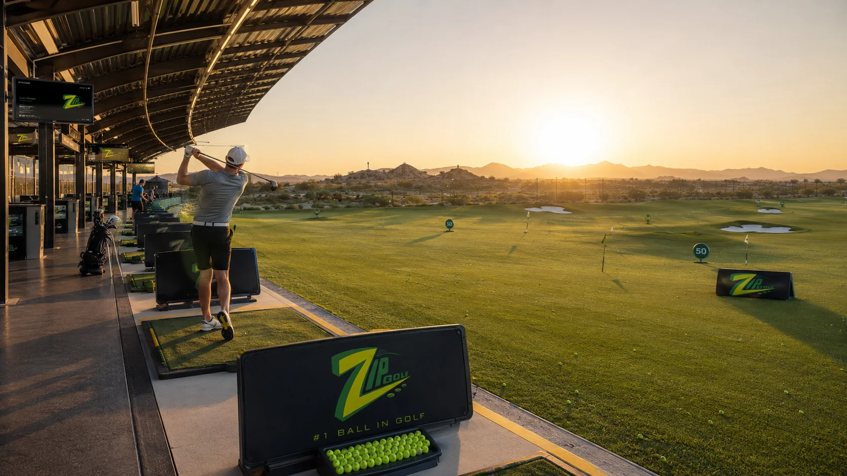 Golfer hitting balls at the Zip Golf driving range during sunrise